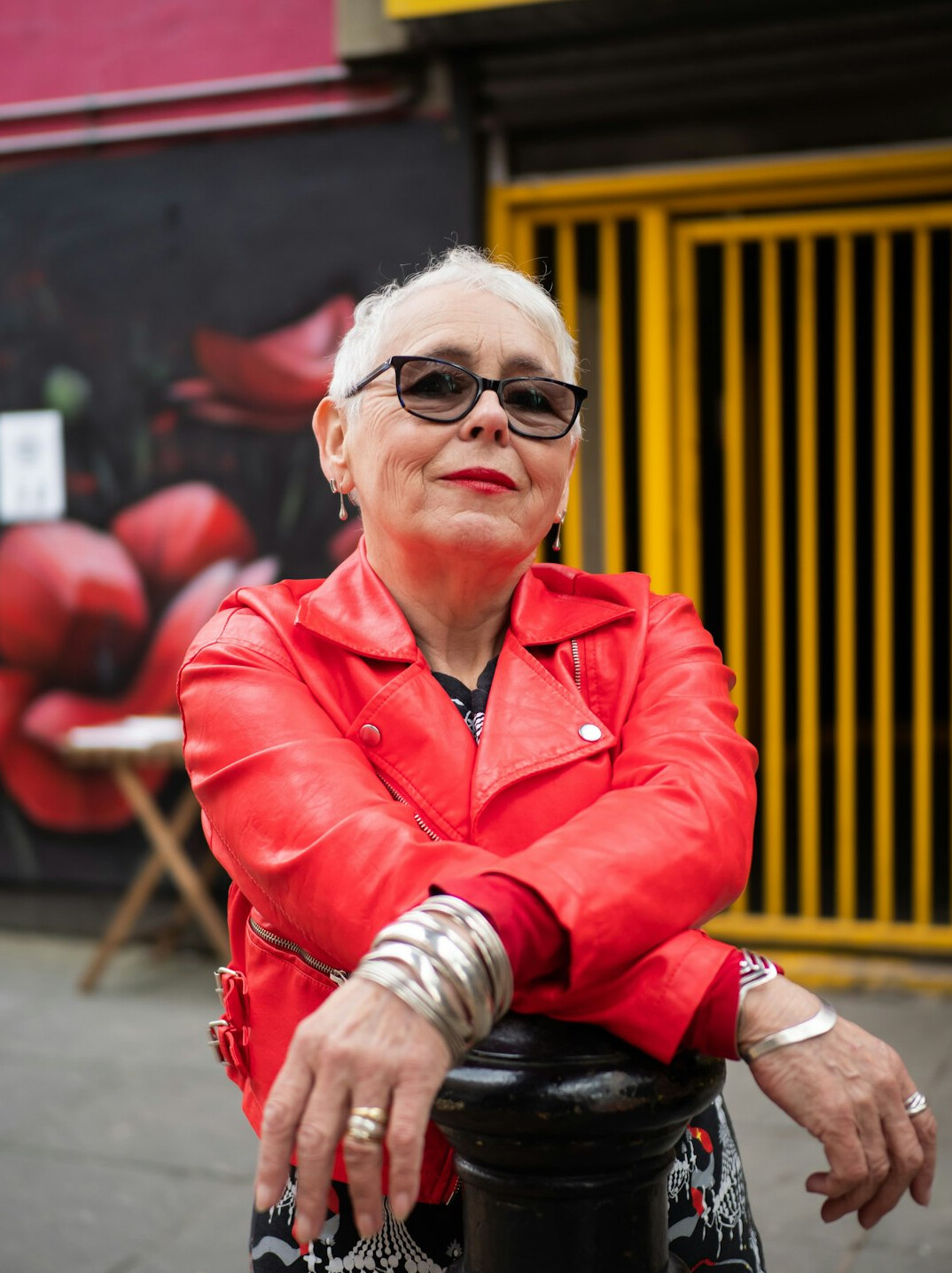 Portrait of a Latina woman in her fifties with short silver hair and a warm smile