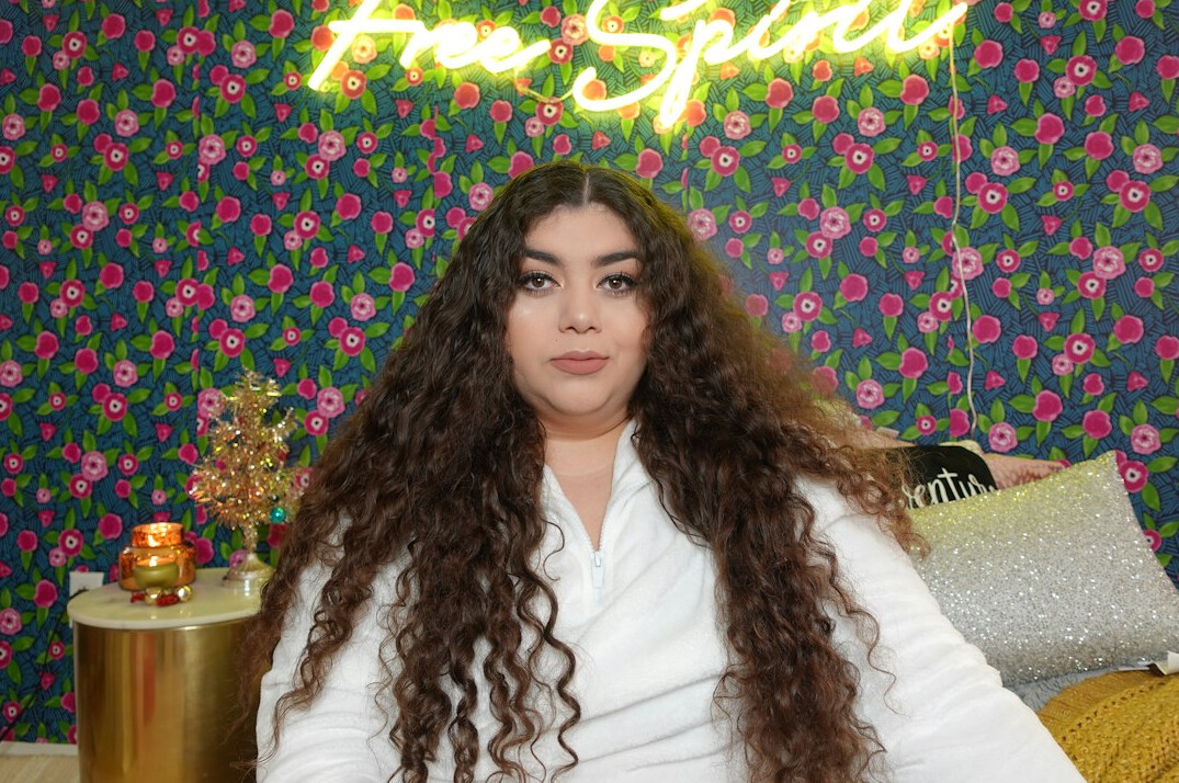 Portrait of a young Latina woman with long wavy hair, TV and streaming reporter