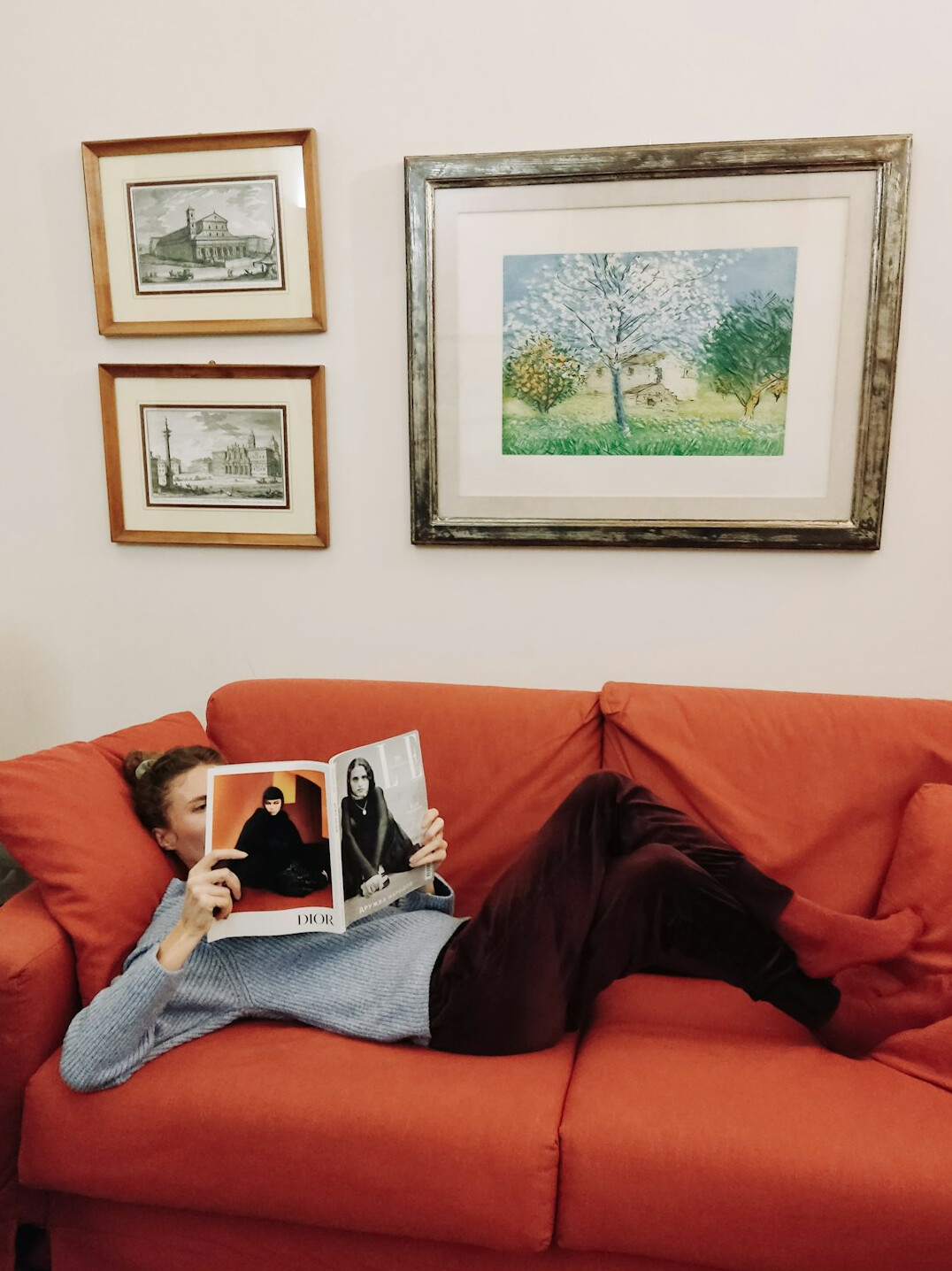 Person reading an entertainment magazine on a tablet in a cozy living room